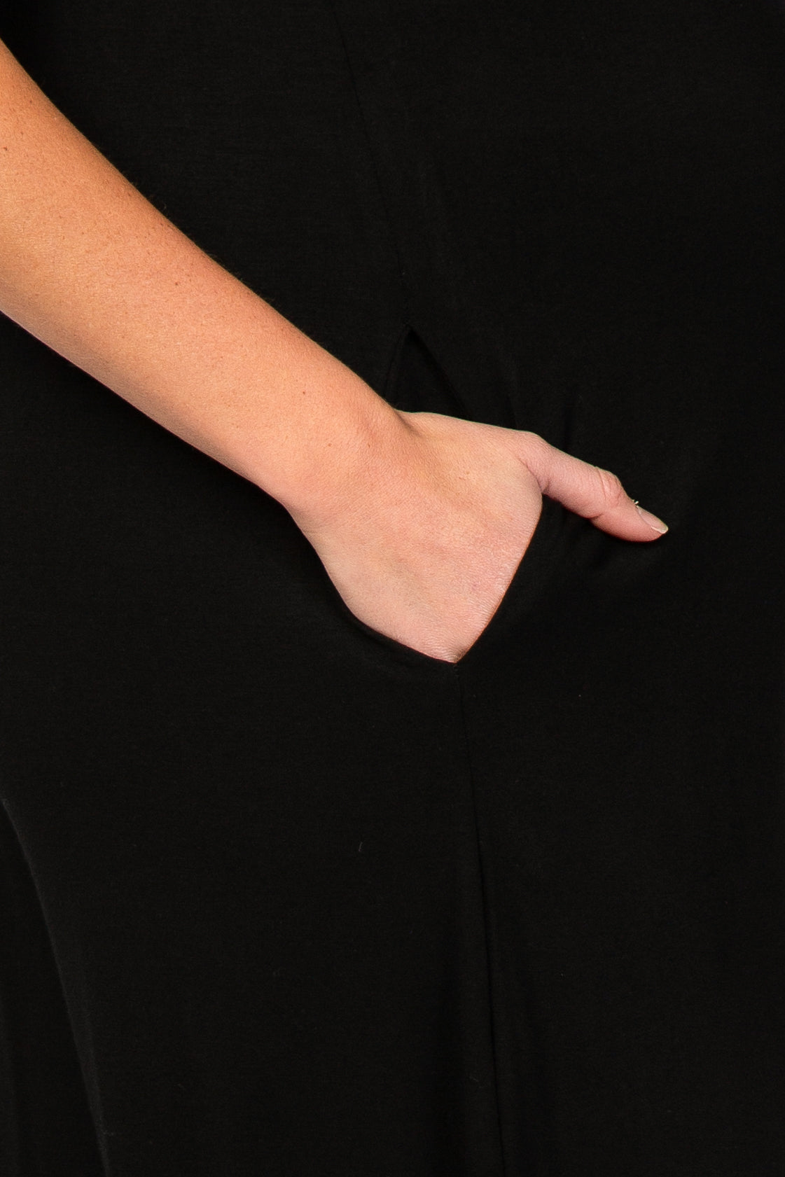 Close up of a hand resting in the side pocket of a black dress