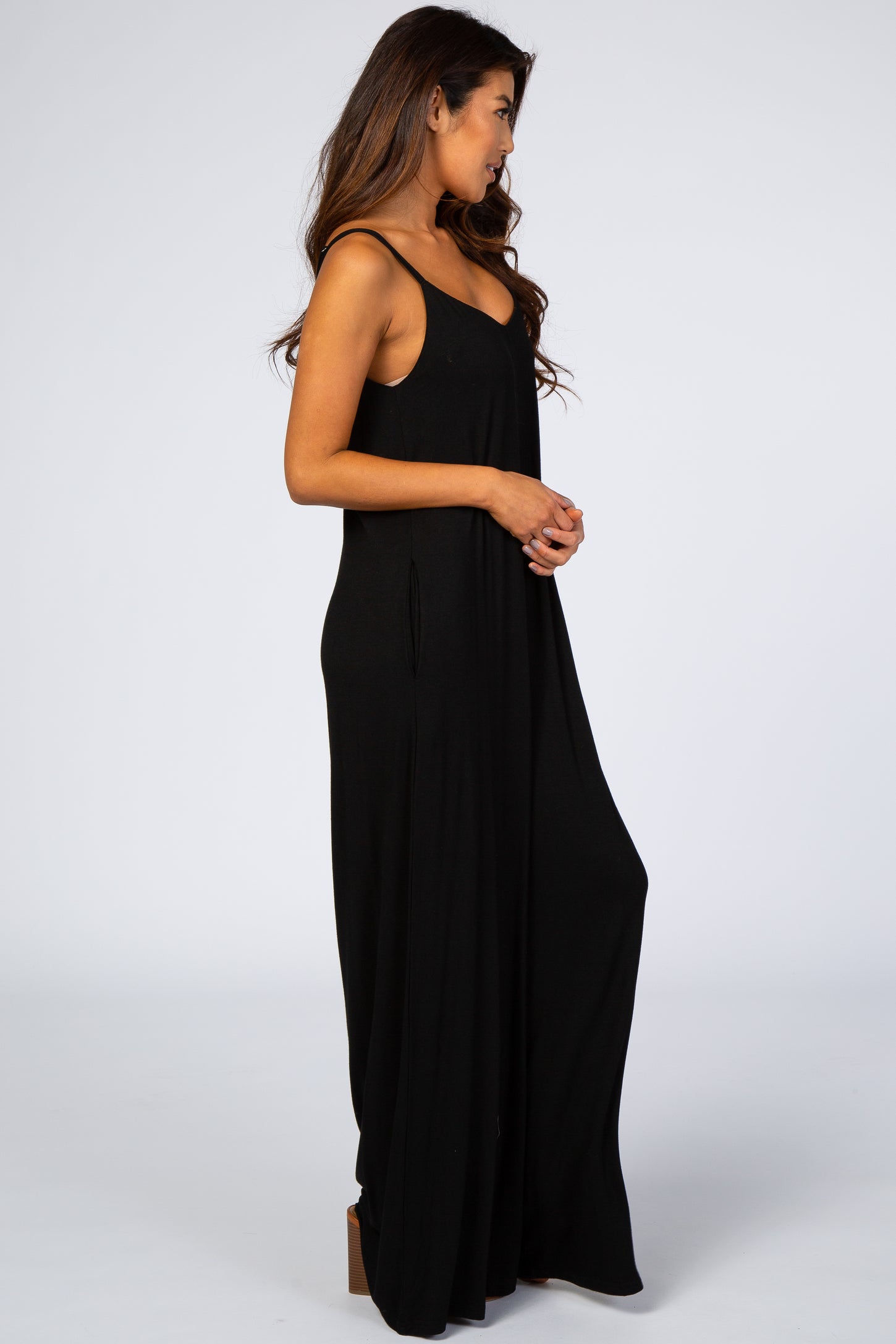 woman wearing a black sleeveless maxi dress with a relaxed fit and side pockets