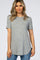 woman wearing a gray short sleeve ribbed top with a slight hem and side slits, paired with blue jeans