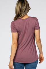 woman wearing a mauve short sleeve top from the back, styled with a curved hem and paired with blue jeans