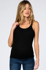 woman wearing a black ribbed maternity tank top and blue jeans against a white background
