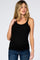 woman wearing a black ribbed maternity tank top and blue jeans against a white background