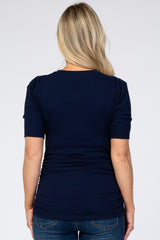 woman wearing a navy blue short sleeve maternity top with a gathered back detail