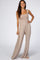 woman wearing a tan smocked strapless jumpsuit with wide legs and a relaxed fit