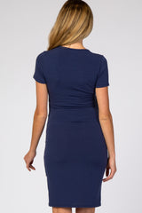 woman wearing a navy blue short sleeve maternity dress with ruching detail on the back