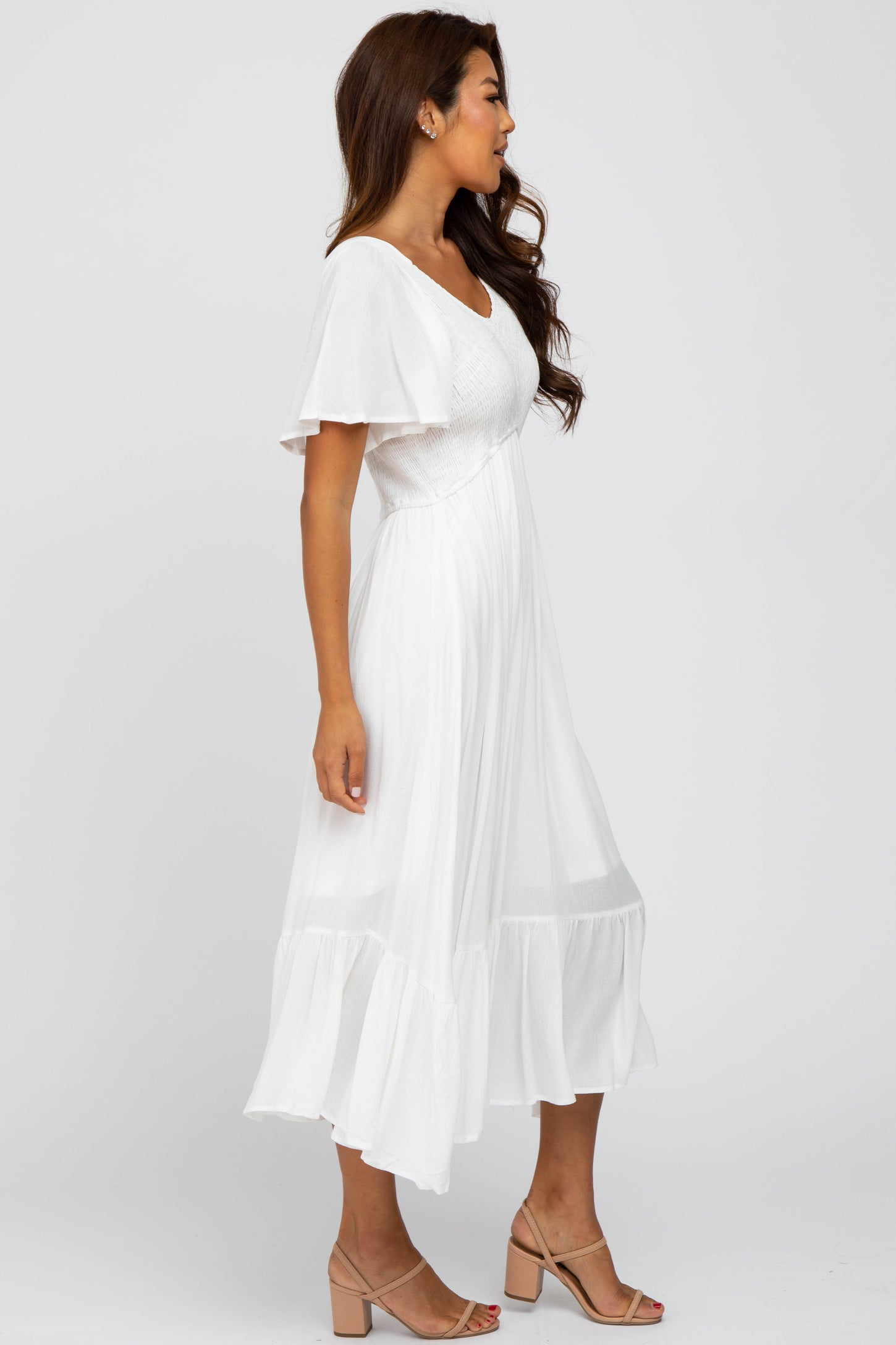 woman wearing a white short sleeve smocked midi dress with ruffle hem and tan block heel sandals