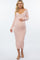 woman wearing a light pink ribbed maternity dress with long sleeves and a fitted silhouette, holding her baby bump