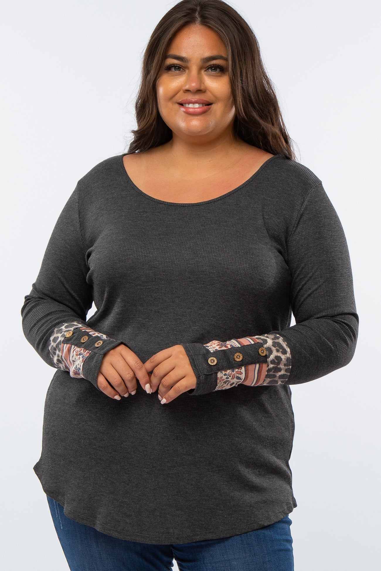 woman wearing a dark gray long sleeve plus size top with patterned sleeve details and buttons