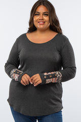 woman wearing a dark gray long sleeve plus size top with patterned sleeve details and buttons