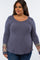 Plus size woman wearing a blue waffle knit long sleeve top with leopard print and floral patterned cuffs