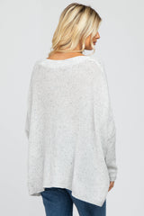 woman wearing a light gray oversized knit sweater with a relaxed fit and dropped shoulders, viewed from the back