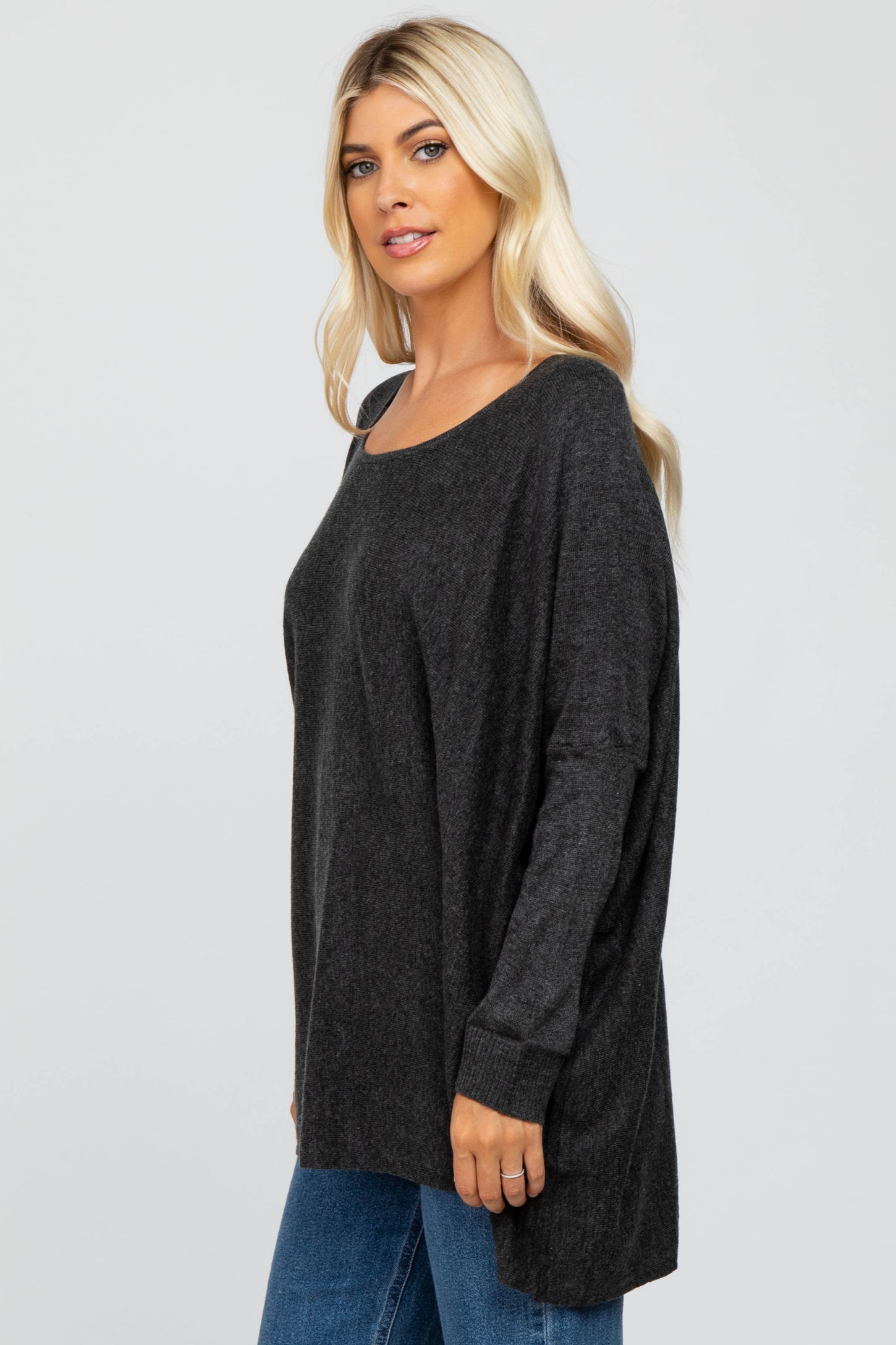 woman wearing a dark gray oversized sweater with long sleeves and a relaxed fit