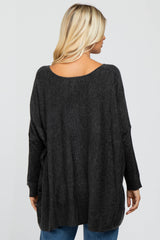 woman wearing a dark gray oversized sweater, viewed from the back, with long sleeves and a relaxed fit