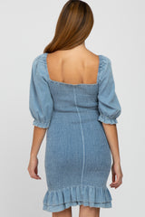 woman wearing a light blue maternity dress with a smocked bodice and puff sleeves, featuring a ruffled hem