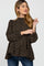 woman wearing a black maternity top with tan polka dots and puff sleeves, styled with blue jeans