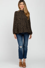 woman wearing black and tan leopard print mock neck blouse with distressed blue jeans and brown mules