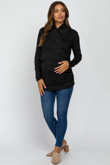 pregnant woman wearing black long sleeve wrap maternity top and blue skinny jeans