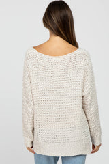 woman wearing a light beige open-knit maternity sweater with a relaxed fit and wide neckline, shown from the back