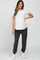 woman wearing a white short sleeve maternity top and gray maternity jogger pants with a baby bump visible