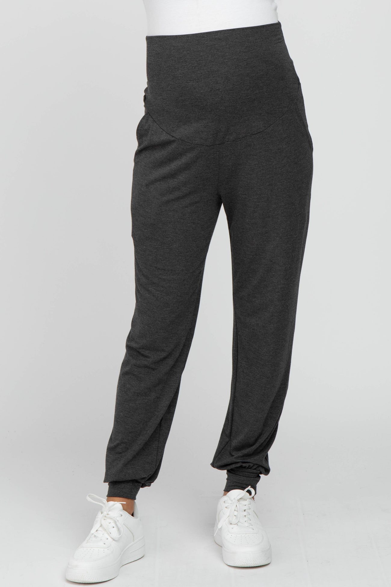 woman wearing dark grey maternity joggers with a high waistband and side pockets