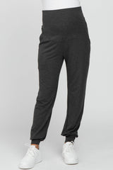 woman wearing dark grey maternity joggers with a high waistband and side pockets
