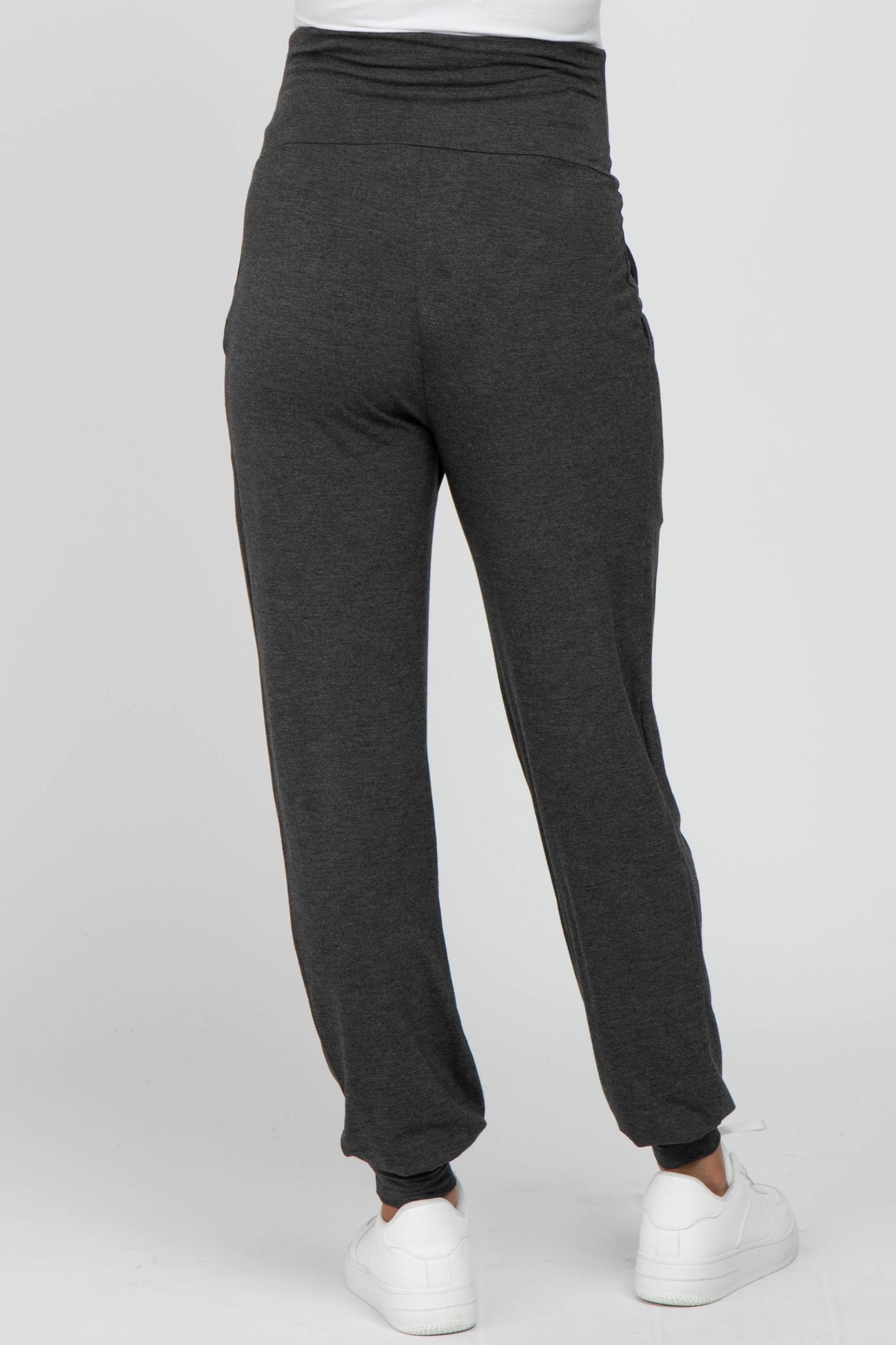 woman wearing dark gray maternity joggers with a high waistband, viewed from the back