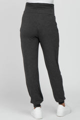 woman wearing dark gray maternity joggers with a high waistband, viewed from the back