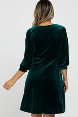 woman wearing a green velvet dress with three-quarter length sleeves and a flared skirt, viewed from the back