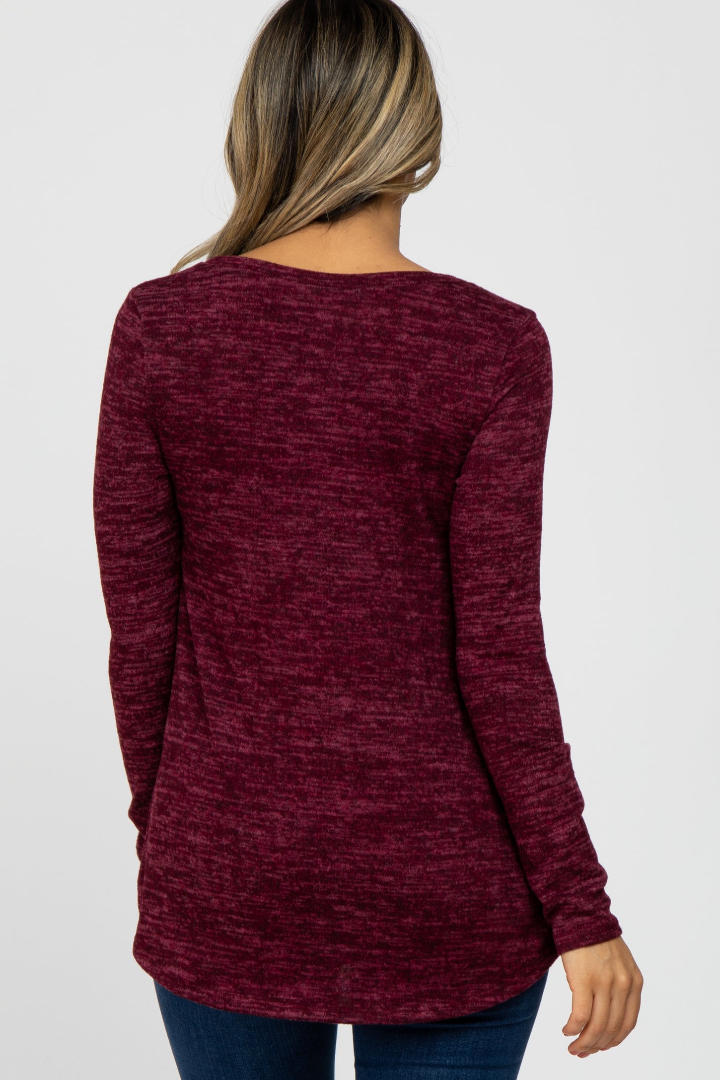 woman wearing a burgundy long sleeve sweater with a relaxed fit, shown from the back
