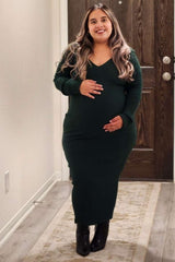 woman wearing a dark green ribbed maternity dress with a v-neck and holding her baby bump