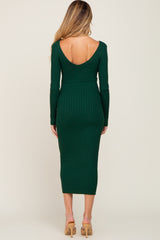 woman wearing a dark green ribbed maternity dress with a deep v-back and long sleeves