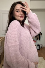 woman wearing a soft pink oversized maternity sweater and highlighting her baby bump
