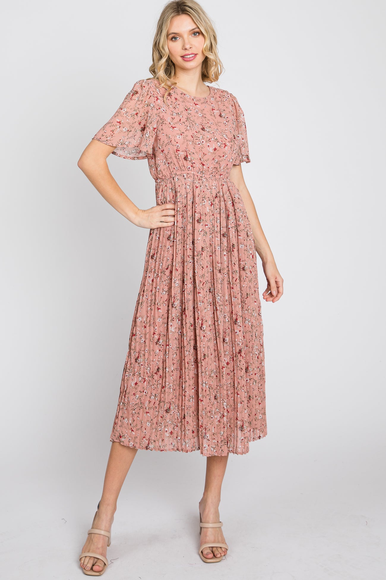 woman wearing a dusty rose floral midi dress with pleated skirt and flutter sleeves