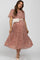 woman wearing a pink floral maternity dress with short sleeves and a pleated skirt, styled with a belt bag