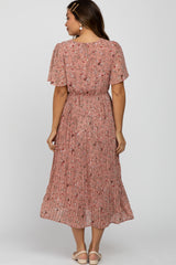 woman wearing a pink floral maternity dress with pleated skirt, showing the back view