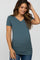 woman wearing a teal v-neck maternity top with ruching, showing her baby bump, paired with jeans
