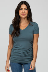 woman wearing a teal v-neck short sleeve fitted top with a gathered side detail and stylish casual look