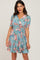 woman wearing a blue floral wrap dress with short sleeves and a tie waist detail