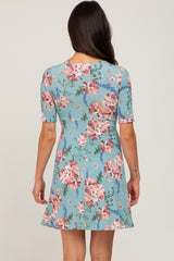 woman wearing a light blue floral short sleeve dress, showing the back view with a flared skirt