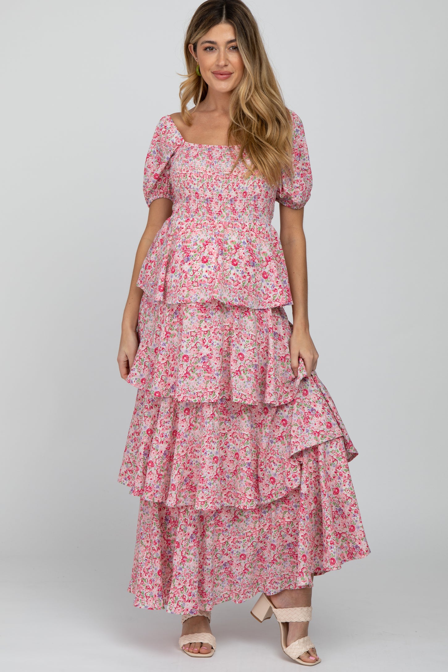 woman wearing a pink floral maternity maxi dress with tiered ruffles and short puff sleeves
