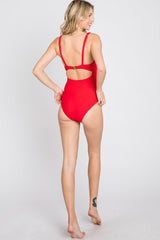 woman wearing a bright red one-piece swimsuit with a cut-out back and adjustable straps
