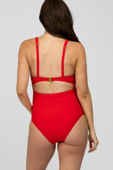 woman wearing a red maternity swimsuit with adjustable straps and a stylish back cutout