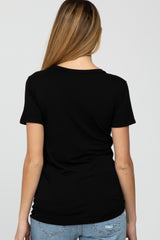woman wearing a black short sleeve maternity top, viewed from the back, paired with light blue jeans