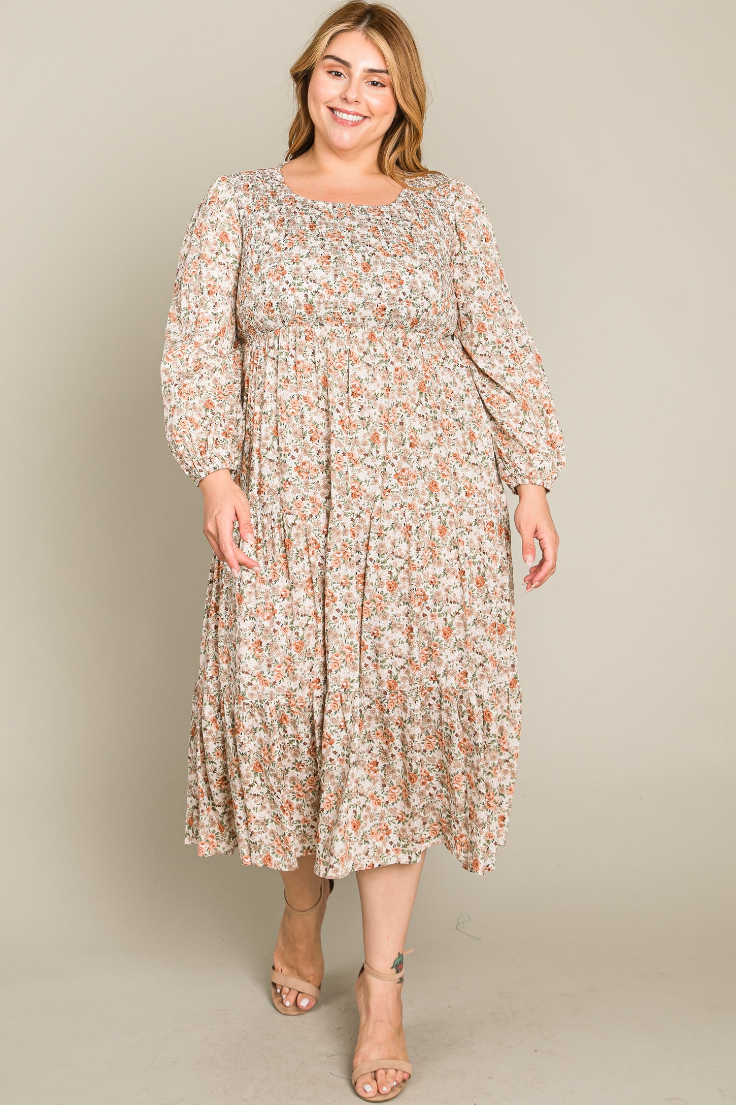 woman wearing a floral long sleeve plus-size dress with a relaxed fit and tiered skirt