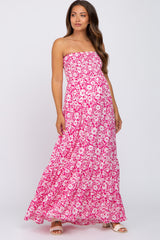 woman wearing a pink floral strapless maxi maternity dress with a fitted bodice and flowy skirt