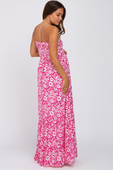 woman wearing a strapless pink floral maxi maternity dress showing her baby bump from the back
