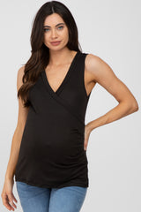 woman wearing a black sleeveless v-neck maternity top and blue jeans