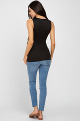 woman wearing a black maternity tank top and blue skinny jeans from the back
