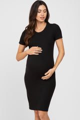 woman wearing a black short sleeve maternity dress and holding her baby bump