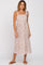 woman wearing a white floral midi dress with square neckline and tie straps, standing in sandals